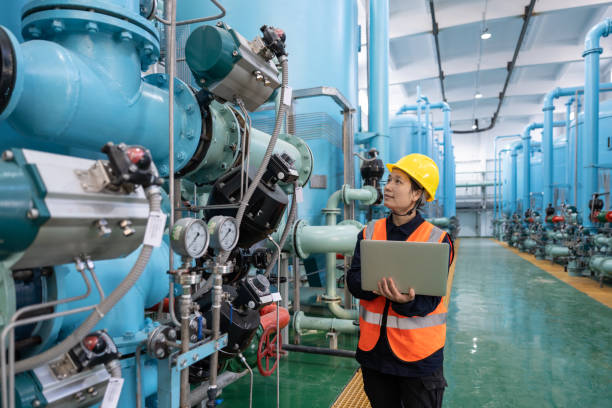 a female engineer works in a chemical plant using a laptop computer Manufacturing Vatsin Technology Solutions